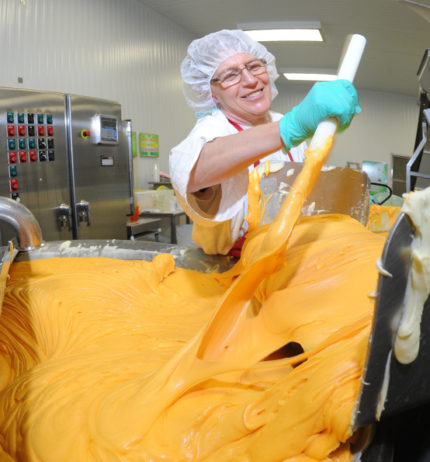 Bel employee stirring cheese